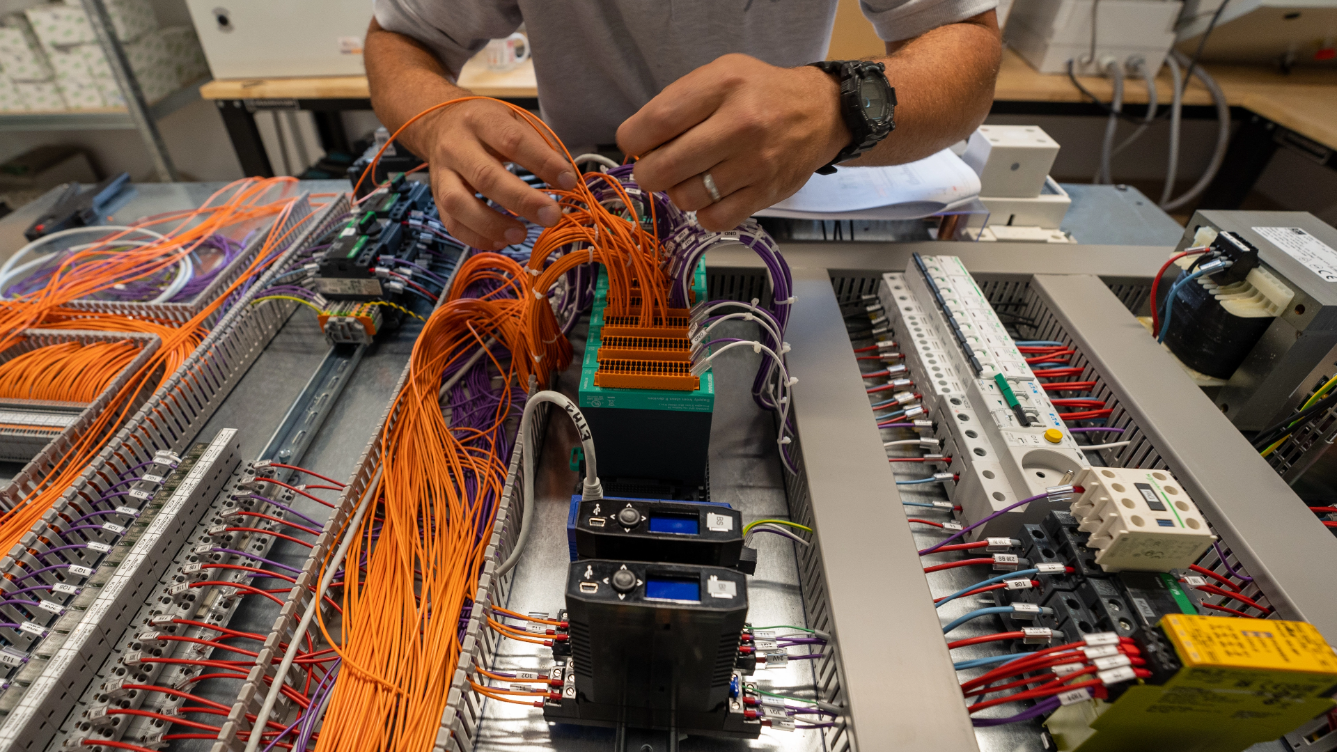 Photo d'un ouvrier réalisant une rénovation sur un tableau électrique